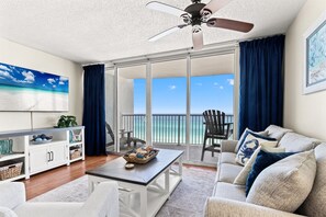 Ein geräumiger Wohnbereich mit Balkon, Deckenventilator und Meerblick.