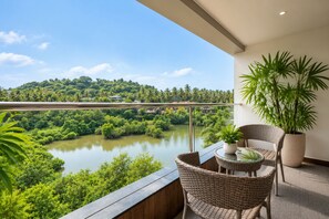 A balcony with wicker furniture, a glass table, and a potted plant. - BluSalzz Collection Casa Onze Goa (Calangute)