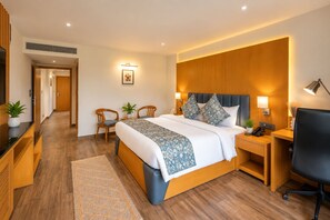 A modern hotel room with a large bed, bedside tables, a desk, and a chair. - BluSalzz Collection Casa Onze Goa (Calangute)