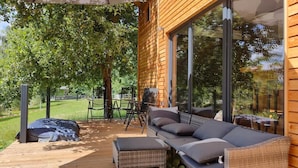 A wooden cabin with a deck, outdoor seating, and large windows. - Tiny House an Zwei Naturteichen - Ruhe, Kamin & Terrasse Nahe Dresden - Best Price! (Grossharthau)