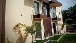 A modern building with a flat roof, large windows, and a balcony.