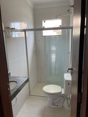 Ein Badezimmer mit Toilette, Duschkabine und Waschbecken.
