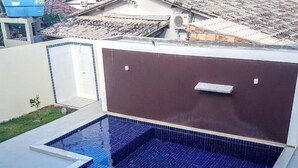 A rectangular swimming pool with a tiled border and a separate shallow area.