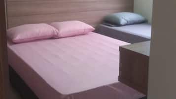 Uma cama de solteiro com cabeceira de madeira, mesa de cabeceira e um travesseiro.