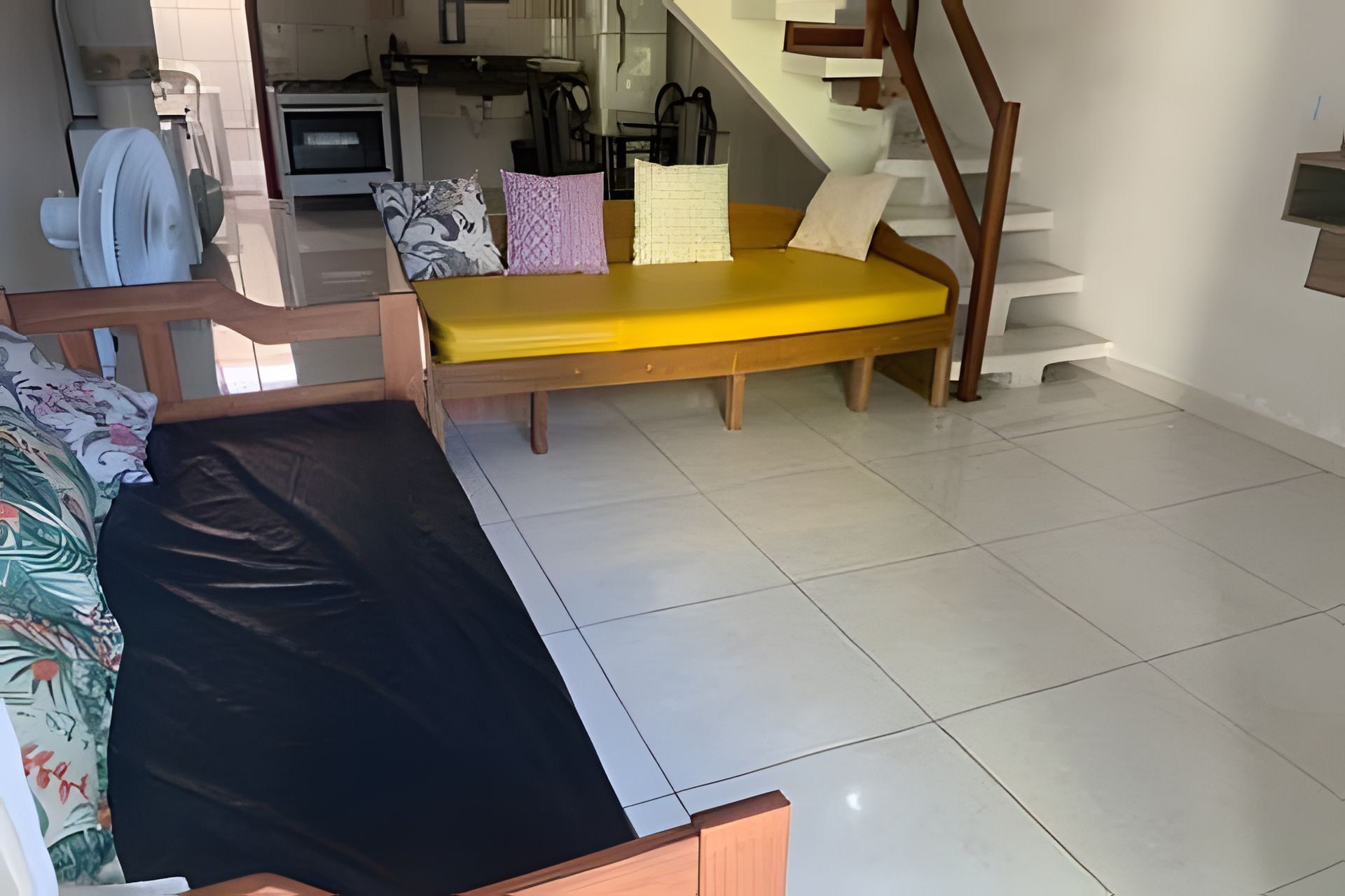 A living area with a sofa, a bench, and a staircase.