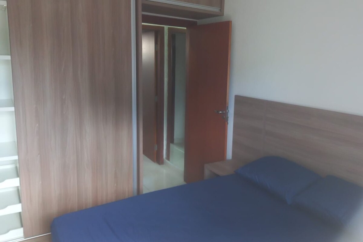 Ein Schlafzimmer mit einem Bett, einem Nachttisch und einem Kleiderschrank.