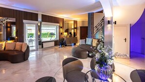 A spacious living area with a sofa, a coffee table, and a decorative vase.