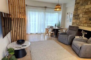 Ein modernes Wohnzimmer mit einer Couch, einem Esstisch und einem Kamin.