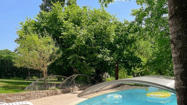 A swimming pool with a covered area, surrounded by trees and a clear sky. - Charming cottage near Loire Castles (La Chapelle-Montmartin)