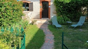 A house with a stone pathway leading to a door, two lawn chairs, and a green fence. - Charming cottage near Loire Castles (La Chapelle-Montmartin)