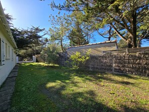 Ein Wohngrundstück mit Haus, Baum und Steinmauer.