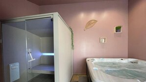 A bathroom with a glass shower enclosure, a bathtub, and a small wall-mounted shelf. - House with AC and parking - 6 guests (Saint-Vincent-Sterlanges)