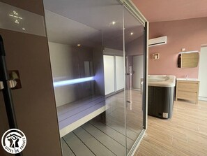 Une salle de bain moderne dotée d’une douche à parois de verre, d’un banc intégré, d’un jacuzzi et d’un meuble-lavabo en bois.
