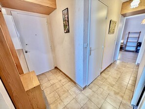 A hallway with a wooden door, a white door, and a white wall with a picture. - Air-conditioned apartment, pets OK, parking - 5 guests (Le Lavandou)