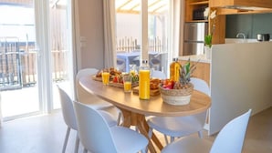 A dining area with a table set for breakfast, including fruits, pastries, and juice. - Mobile home with AC - Pets OK - 6 guests (Frontignan)
