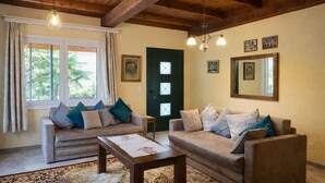 Una sala de estar con dos sofás, una mesa de centro y una puerta con ventanas.