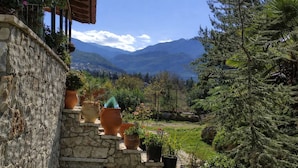 A stone wall with potted plants and a view of mountains. - Villa Dorothy - Mountain View Retreat Polydrosos (Delphi)