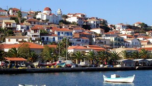 A coastal town with buildings, boats, and palm trees. - Beachfront Nest Memi Koroni-seaheaven House A3 (Pylos-Nestoras)