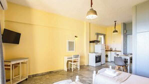 A hotel room with two beds, a desk, a chair, a TV, and a kitchenette. - Beachfront Nest Memi Koroni-seaheaven House A3 (Pylos-Nestoras)