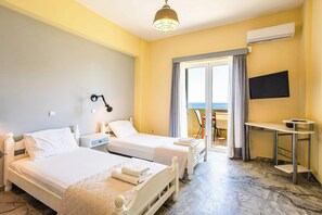 A hotel room with two beds, a desk, a TV, and a balcony with a view. - Beachfront Nest Memi Koroni-seaheaven House A1 (Pylos-Nestoras)
