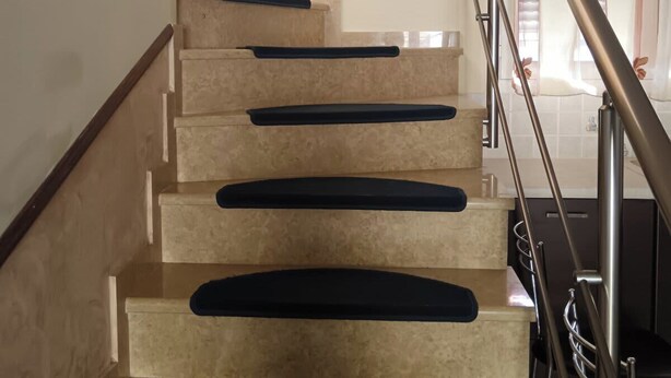 A staircase with a handrail, beige steps, and a wall with a light switch. - Bussiness Maisonette Getaway 5 min From the Beach (Kymi-Aliveri)