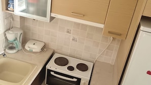 A kitchen with a stove, sink, and cabinets. - Bussiness Maisonette Getaway 5 min From the Beach (Kymi-Aliveri)