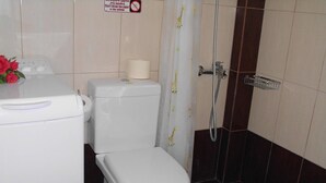 A bathroom with a toilet, a shower, and a trash bin. - Bussiness Maisonette Getaway 5 min From the Beach (Kymi-Aliveri)