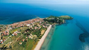 An aerial view of a coastal town with a beach, residential areas, and a small island. - Beachfront Nest Memi Koroni-seaheaven House B3 (Pylos-Nestoras)