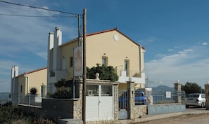 A two-story building with a beige facade, a balcony, and a sign indicating 'Villa Christine.' - Family Apartment Cozy Getaway 5 min From the Beach (Kymi-Aliveri)