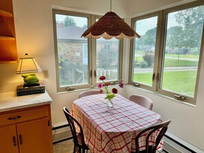 A dining area with a table set for two, a hanging lamp, and a view of the outside. - Perfect Notre Dame home, ND football and events, Rent directly from ND faculty (South Bend)