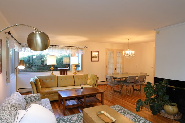 A living room with a sofa, coffee table, dining table, chairs, and a chandelier. - Perfect Notre Dame home, ND football and events, Rent directly from ND faculty (South Bend)