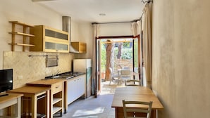 Una cocina compacta con zona de comedor, televisor y vistas al exterior.