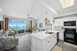 Una cocina moderna con armarios blancos, estufa negra y una isla grande.