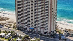 A high-rise hotel with multiple floors, a beach view, and a parking area. - Gulf-Front Sunrise Beach Resort | Family Favorite | Sleeps 8 | Near Pier Park (Panama City Beach)