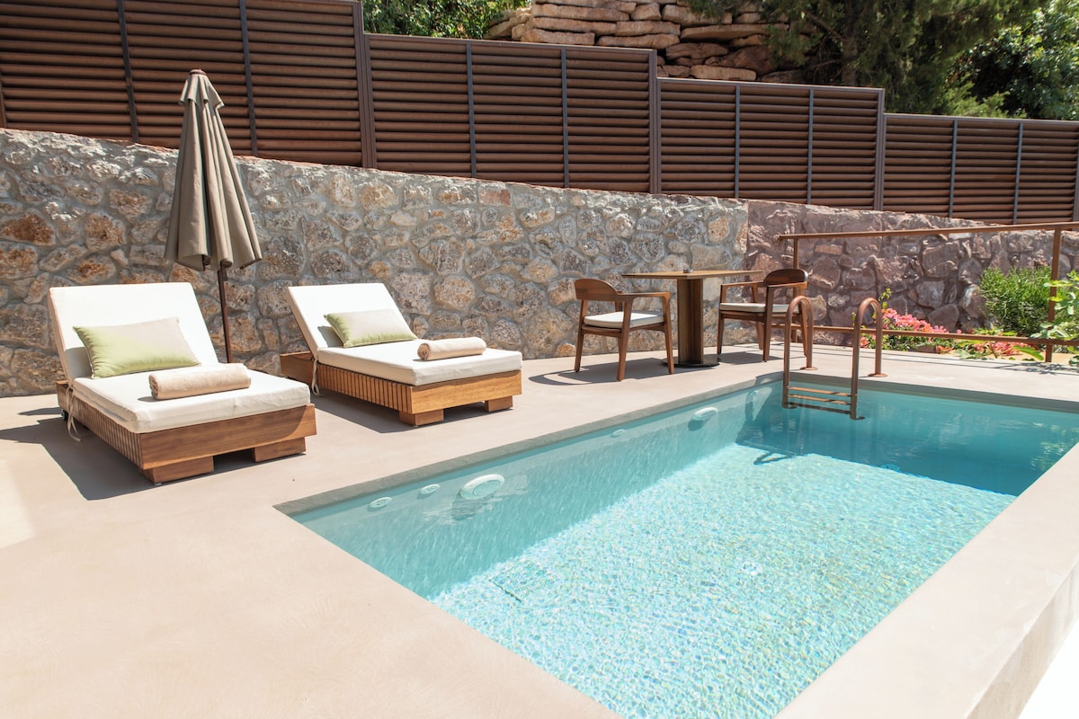 A pool area with lounge chairs and a table.