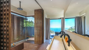 A modern bathroom with a bathtub, a shower area, and a large window with a view of the sea. - Klay Hotel Faralya Adults Only (Fethiye)