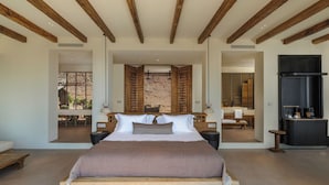 A spacious bedroom with a large bed, wooden beams, a modern bathroom, and a kitchen area. - Klay Hotel Faralya Adults Only (Fethiye)