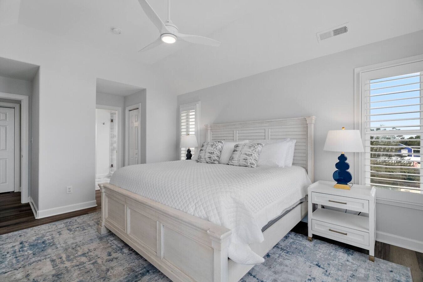 A bedroom with a bed, nightstands, a lamp, and a ceiling fan.