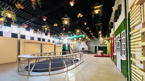 A spacious indoor area with a circular viewing platform, a brick fireplace, and a green wall with a window. - Hotel Green Garden in Ludhiana, Couple friendly Near Railway Station (Ludhiana)