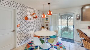 A dining area with a round table, white chairs, and a colorful rug. - Pool & Patio! Mod Desert Digs Near Lake Havasu (Lake Havasu City)
