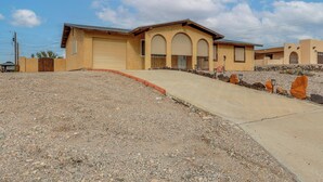 A single-story building with a garage, a driveway, and a gravel area. - Pool & Patio! Mod Desert Digs Near Lake Havasu (Lake Havasu City)