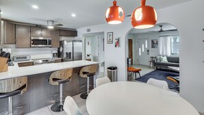 A modern kitchen with a central island, bar stools, and pendant lighting. - Pool & Patio! Mod Desert Digs Near Lake Havasu (Lake Havasu City)