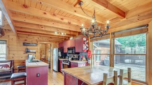 A cabin interior with a wooden interior, a kitchen area, and a dining space with a view. - Spacious Log Cabin w/ Stunning Views in Blue Ridge (Blue Ridge)