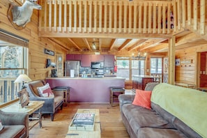 A wooden cabin interior with a living area, kitchen, and a dining table. - Spacious Log Cabin w/ Stunning Views in Blue Ridge (Blue Ridge)