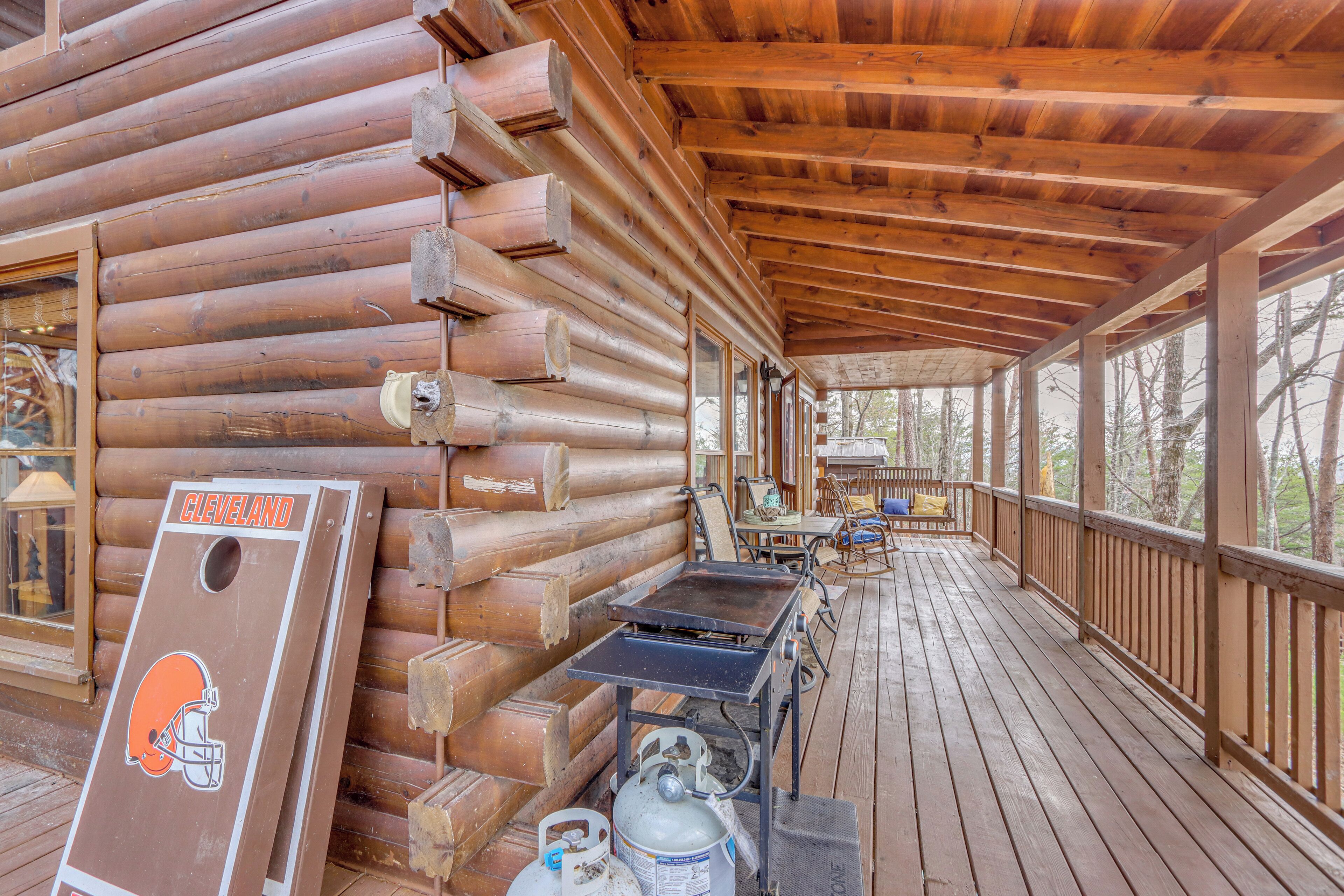 Eine Holzblockhütte mit verdeckter Veranda, einem Tisch mit Stühlen und einem Schild mit dem Schriftzug Cleveland Browns.