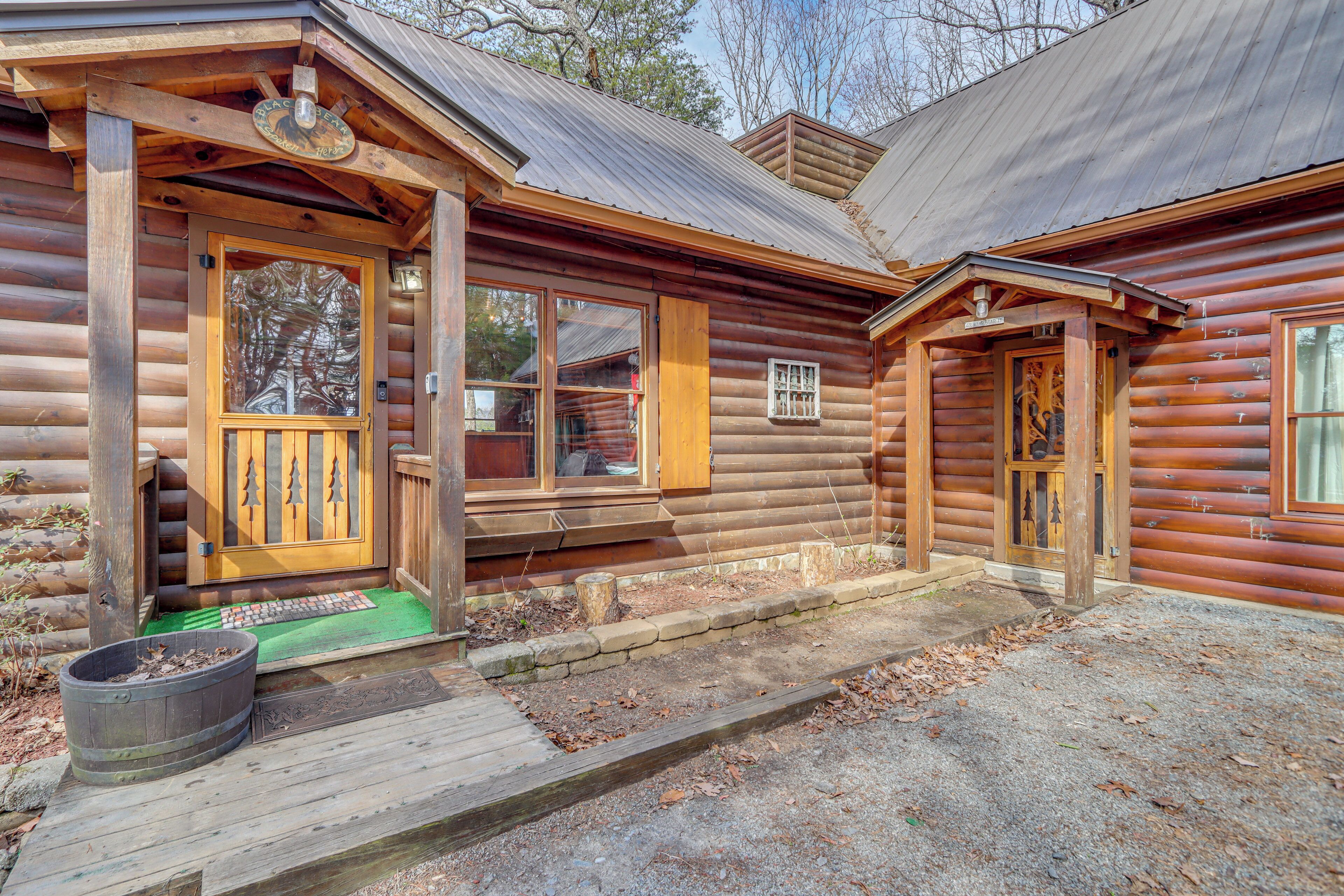 Una baita di legno con un portico, una porta d'ingresso e una finestra.
