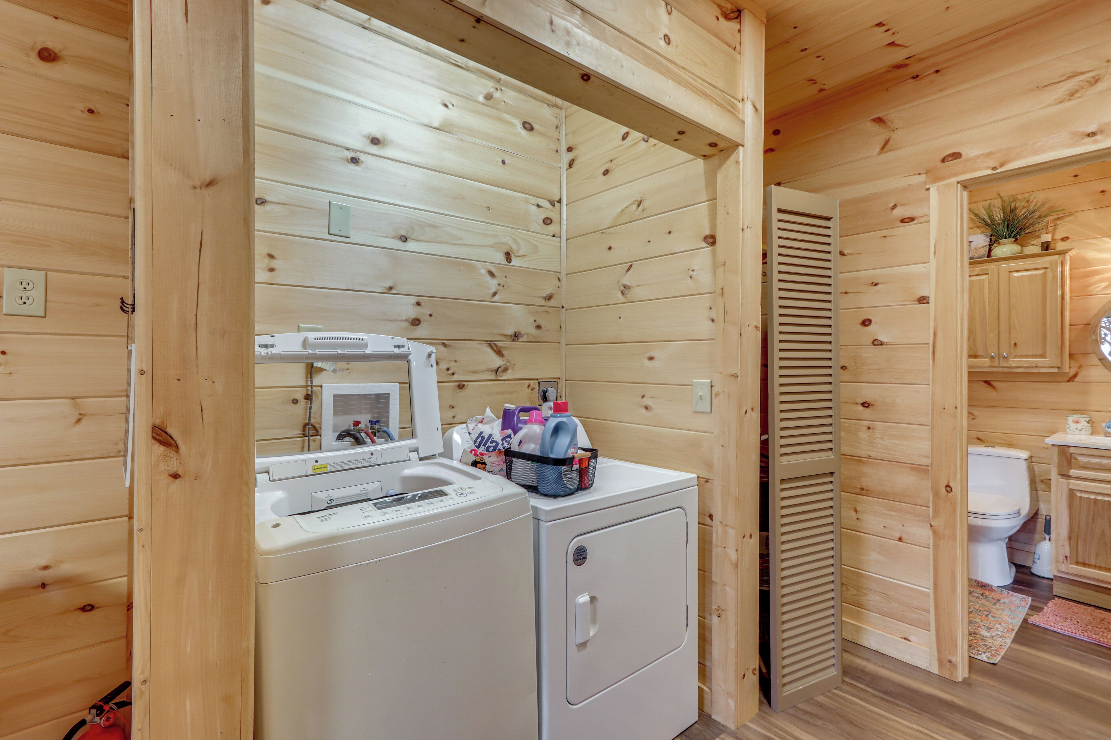 L’intérieur d’une cabane en bois, avec un lave-linge, un four à micro-ondes et des toilettes.