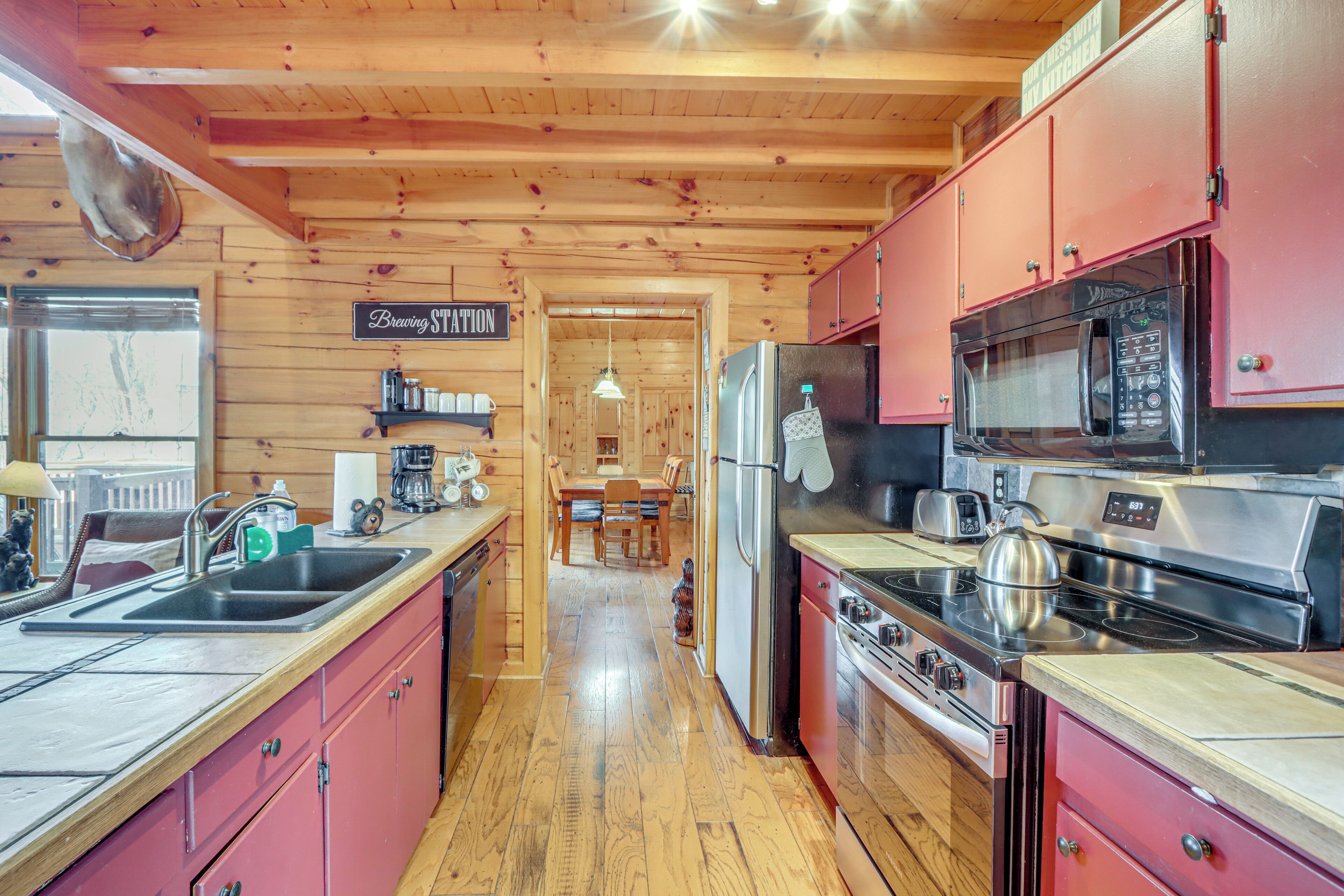 A kitchen with wooden walls, a refrigerator, a stove, and a microwave.