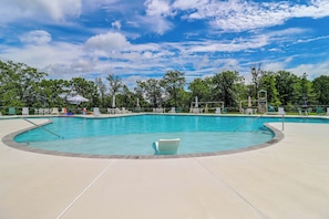A swimming pool with a curved edge, surrounded by lounge chairs and umbrellas, under a clear sky. - Near Slopes, Trails & Fun! Camelback Townhome (Tannersville)