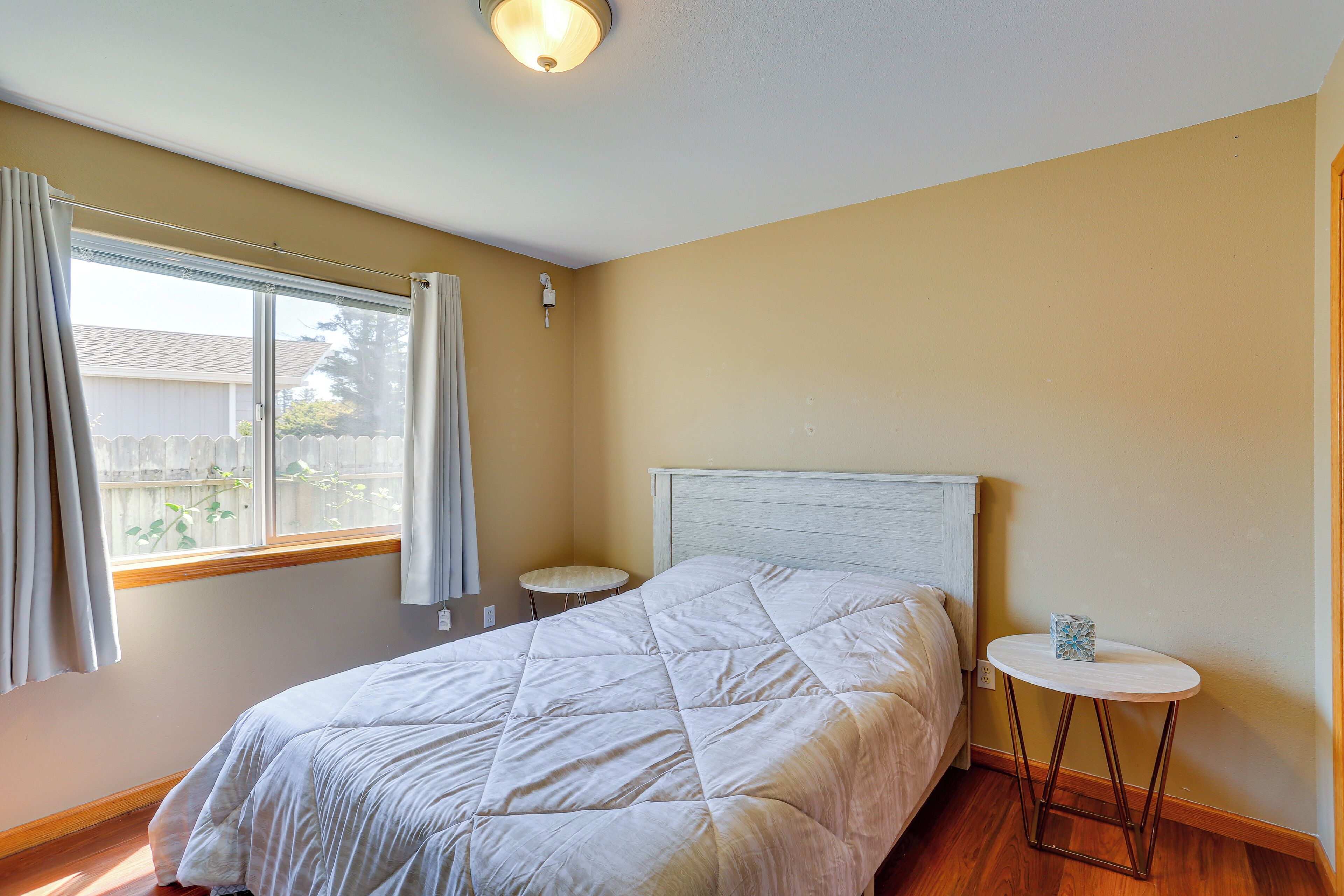 Ein Schlafzimmer mit einem Bett, einem runden Tisch und einem Fenster mit Vorhängen.